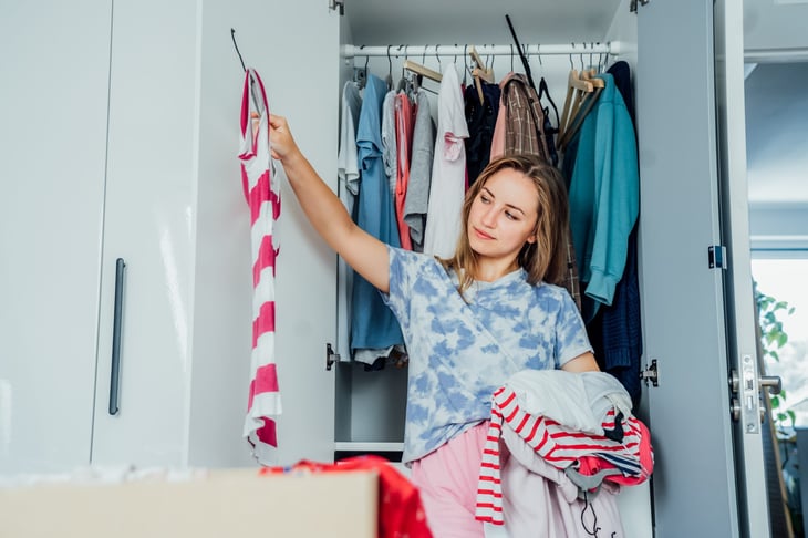 Woman looking through clothing to donate or get rid of.