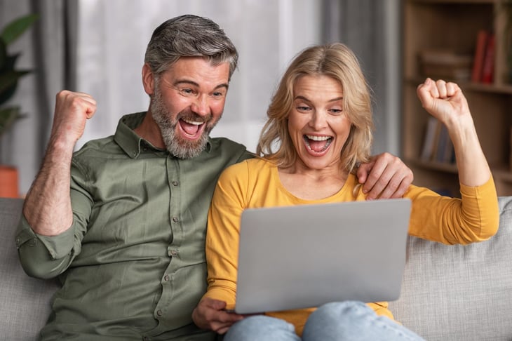 Excited couple looking at a laptop computer