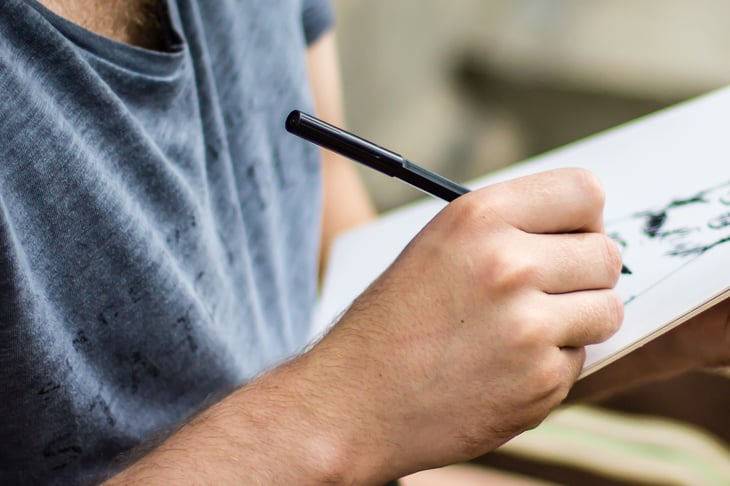 A man draws in a sketchbook