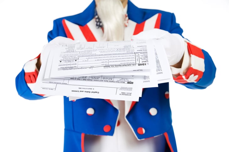 Uncle Sam holding tax forms