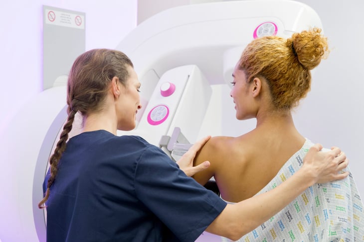 Radiographer guiding a patient through a mammogram