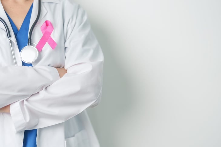 Doctor wearing a pink ribbon for breast cancer awareness