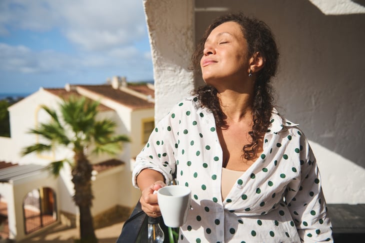 Woman enjoying the sunshine on her balcony