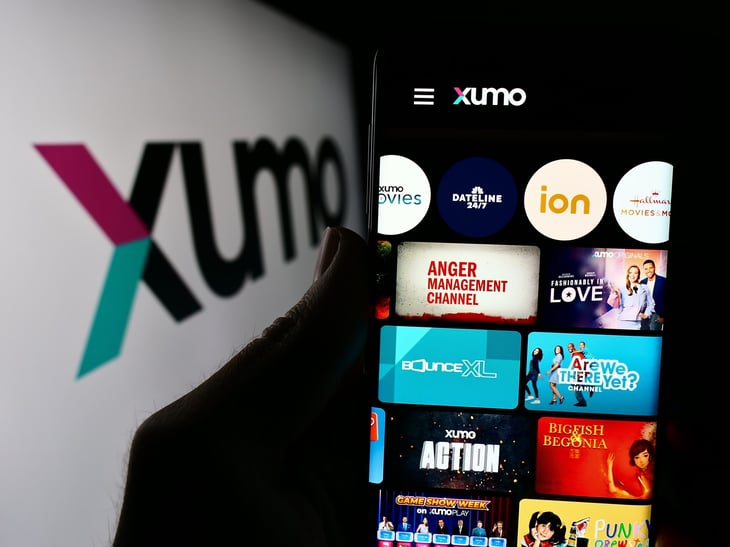 Xumo app open on a smartphone with the label displayed in the background
