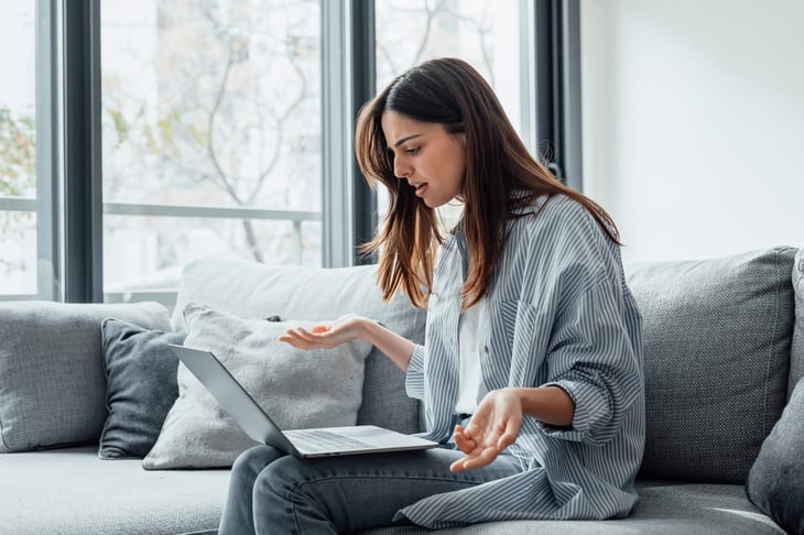 upset woman looking at laptop