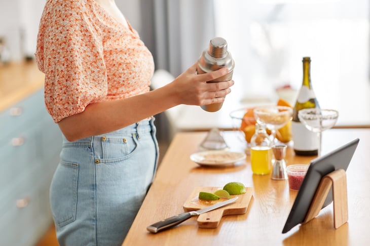 Woman prepping drinks in home bar.