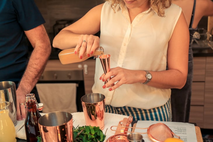Woman using her home bar to make drinks.