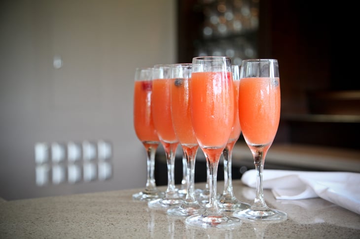 Fresh fruit strawberry, orange and champagne mimosa cocktails at a bar
