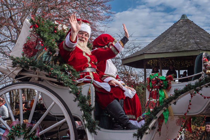 Holiday parade in St. Charles, Missouri with a float featuring Mr. and Mrs. Santa Claus.