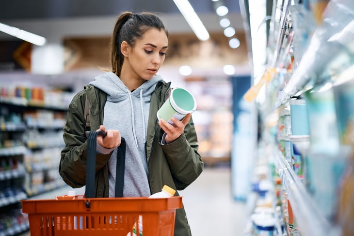 Woman looking at a food label in a grocery store