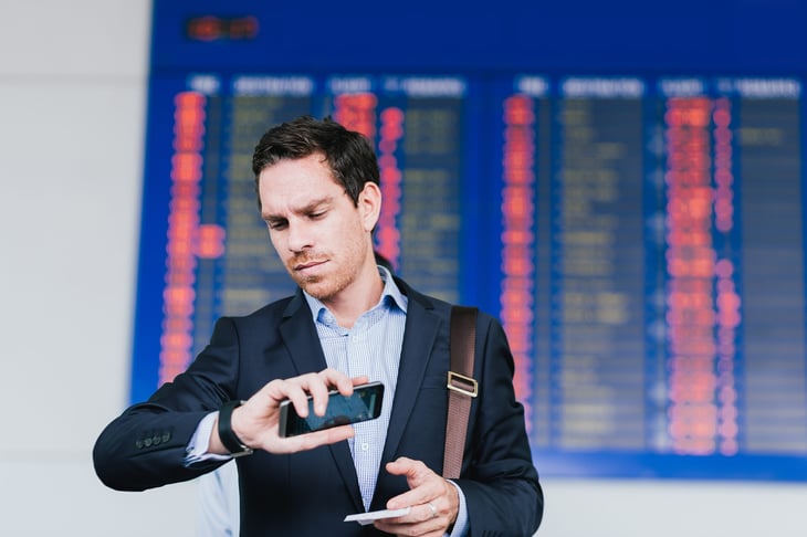 Man with airline schedule waiting for plane.