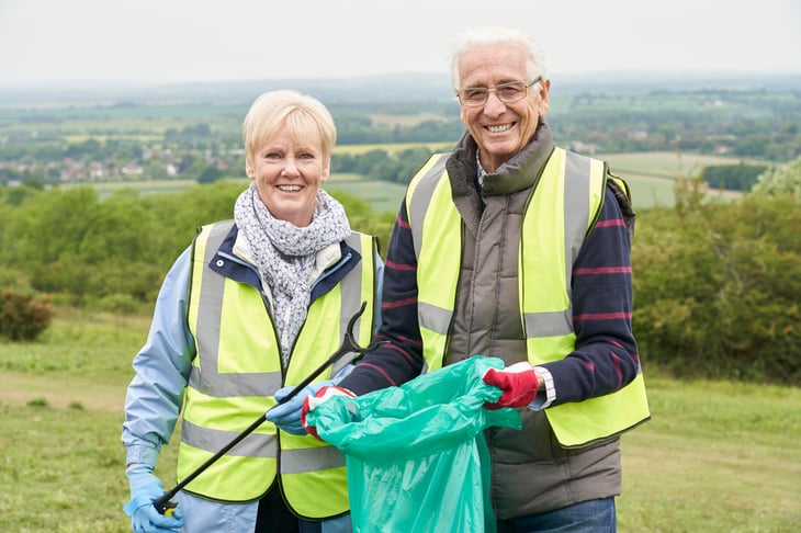 Senior man and woman working as volunteers for trash pickup.