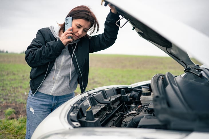 Woman with a broken down car calling for help.