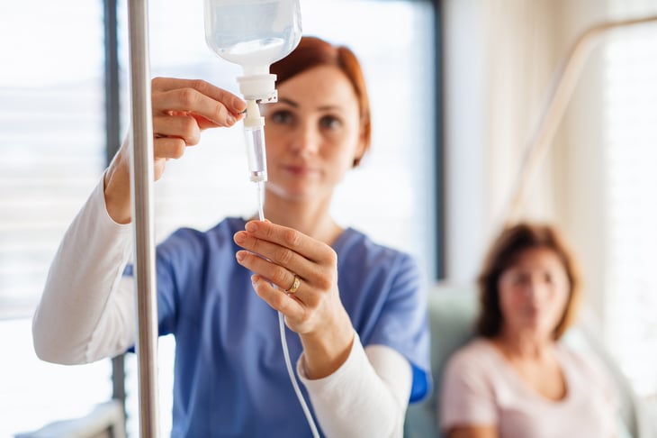 Nurse hooking up an IV drip to give a patient an infusion