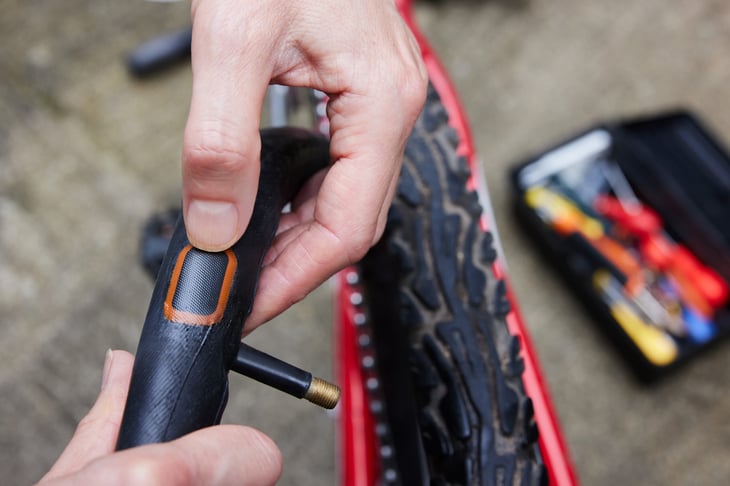 Person Repairing Puncture In Bike Tire With Patch
