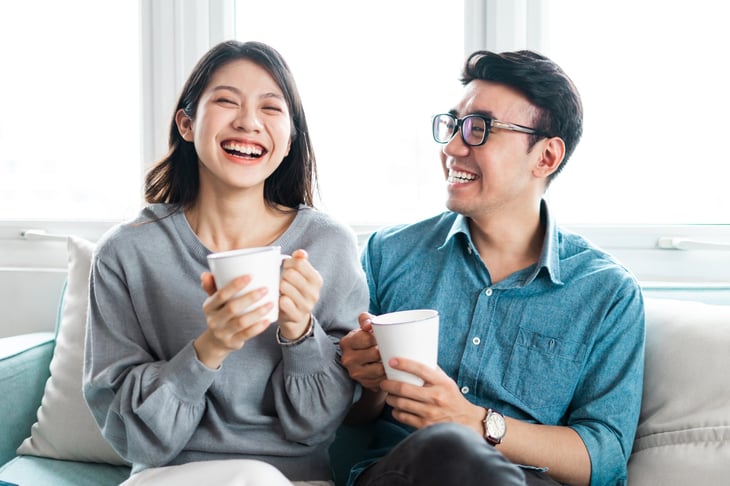 Happy couple drinking coffee at home