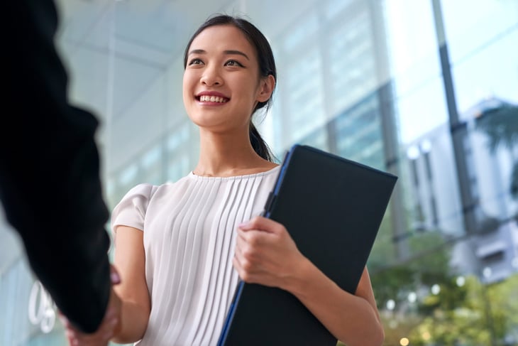 Smiling woman accepting a job offer and shaking a hand