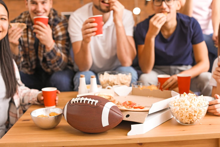 Group of friends eating and watching football game