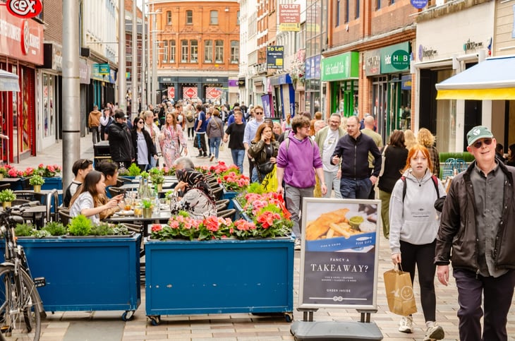 People eating outside a brightly decorated restaurant on Ann Street, Belfast, Northern Ireland
