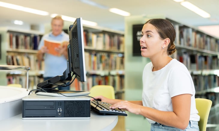 Young woman using a computer in a public library