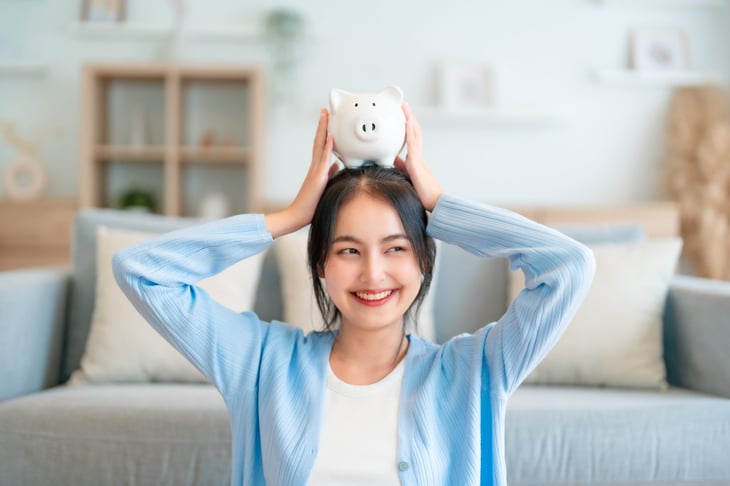 Smiling woman holding a piggy bank
