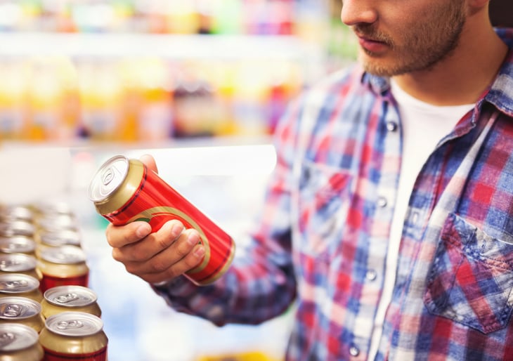 Man picking up a beer can at the grocery store