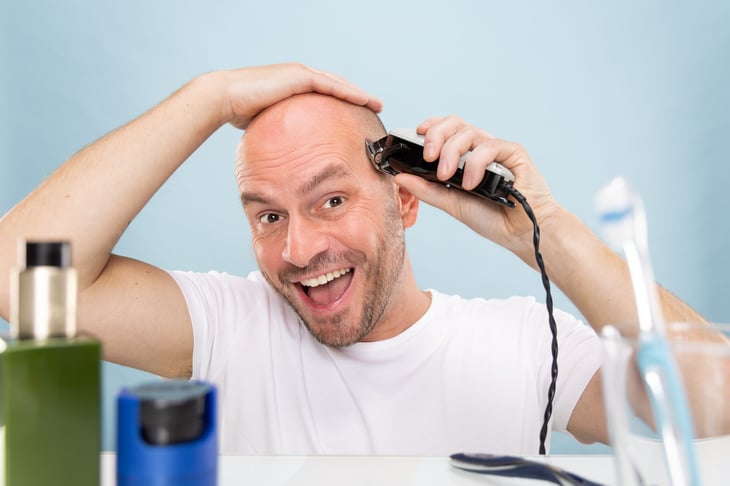 Man shaving his head bald
