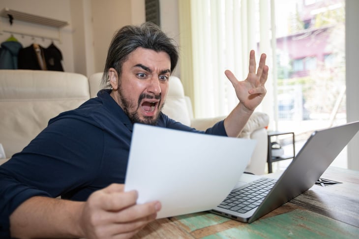 Upset man looking at a big bill