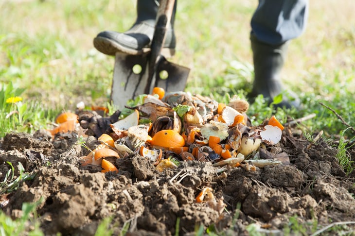 Person digging a compost pile outside