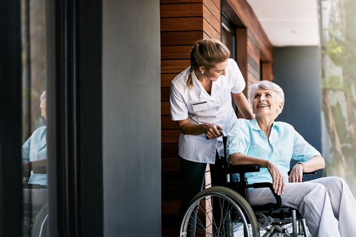 Nurse helping an older woman in a wheelchair