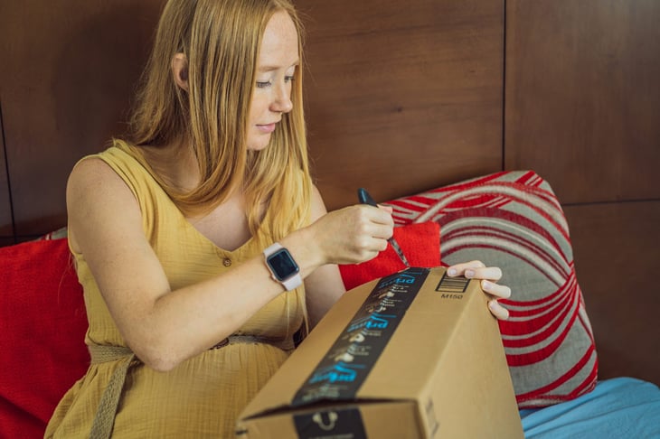 Pregnant mother opening an Amazon box