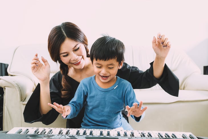 Mom and kid playing a piano