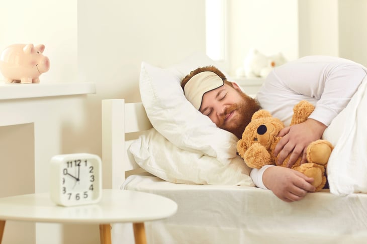 Man sleeping soundly with a teddy bear