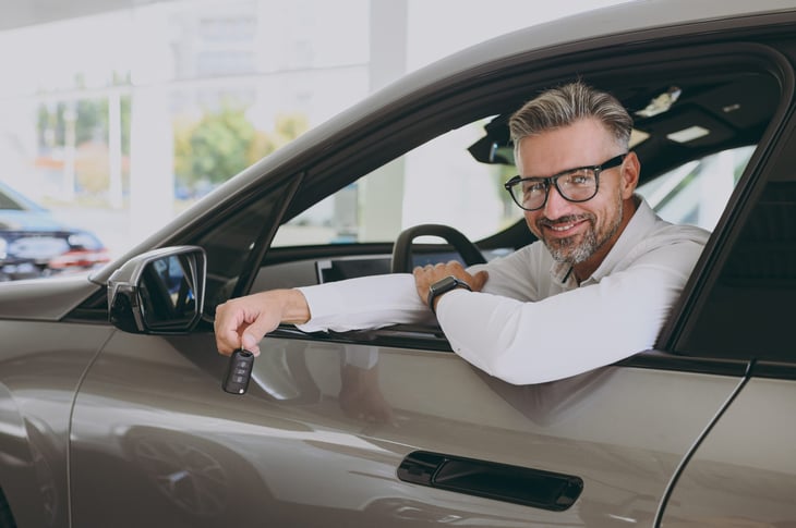 Man about to drive his new car from the dealership