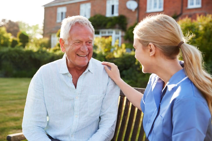 A man in senior care talks to an aide