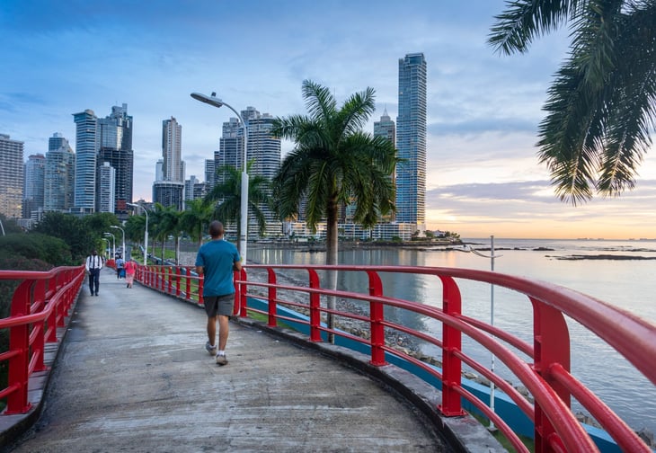 Panama City, Panama. Late afternoon with people walking on a pedestrian overpass next to Cinta Costera (Coastal Beltway)