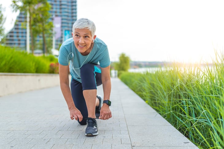 Senior woman tying her running shoes and getting ready to walk or exercise.