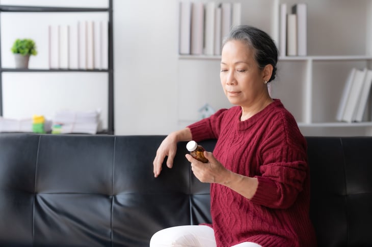Senior woman looking at a pill bottle