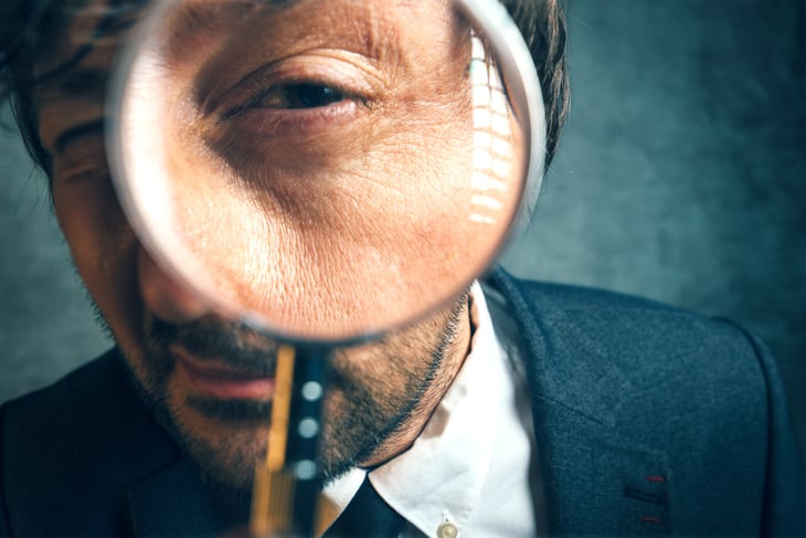 Business professional holding a magnifying glass