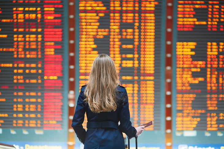 Woman in front of flight board