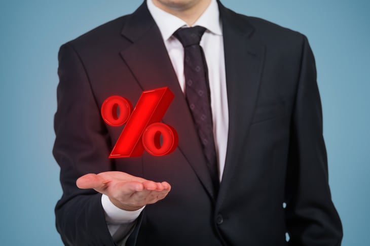 Businessman holds a floating percent sign