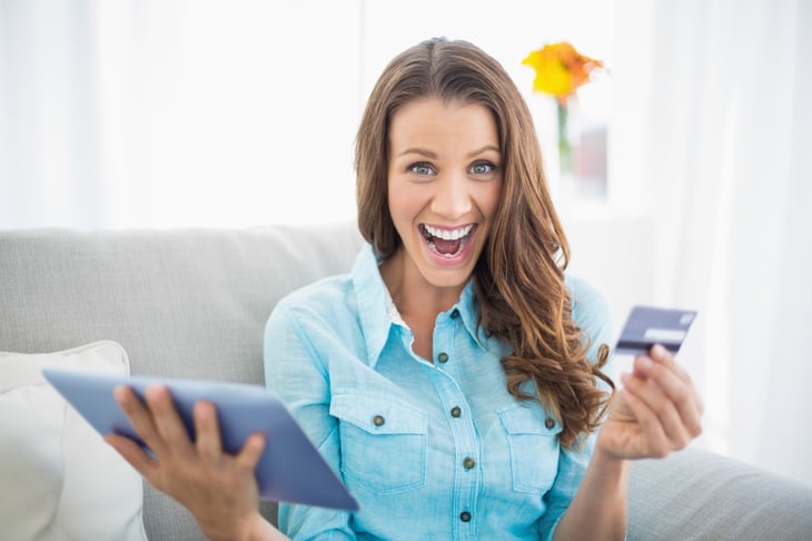Happy woman with computer, credit card.
