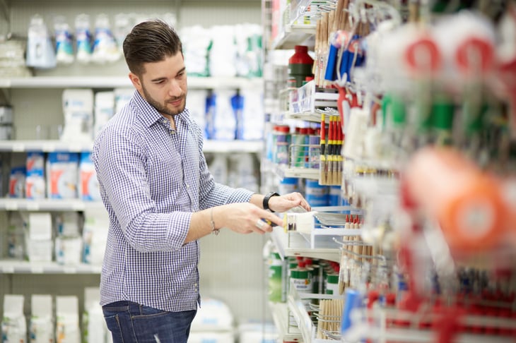 A man shops for painting supplies at a hardware store