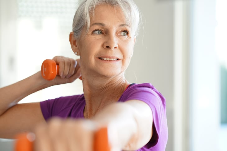 A woman exercises with dumbbells