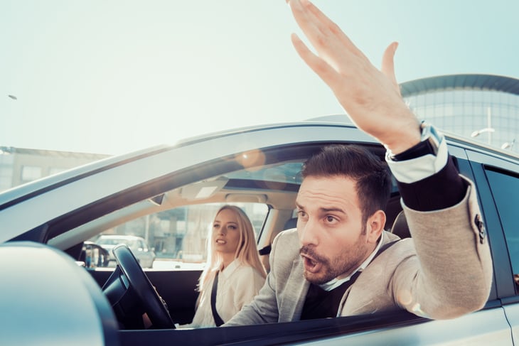 Angry driver in traffic gestures with his hand